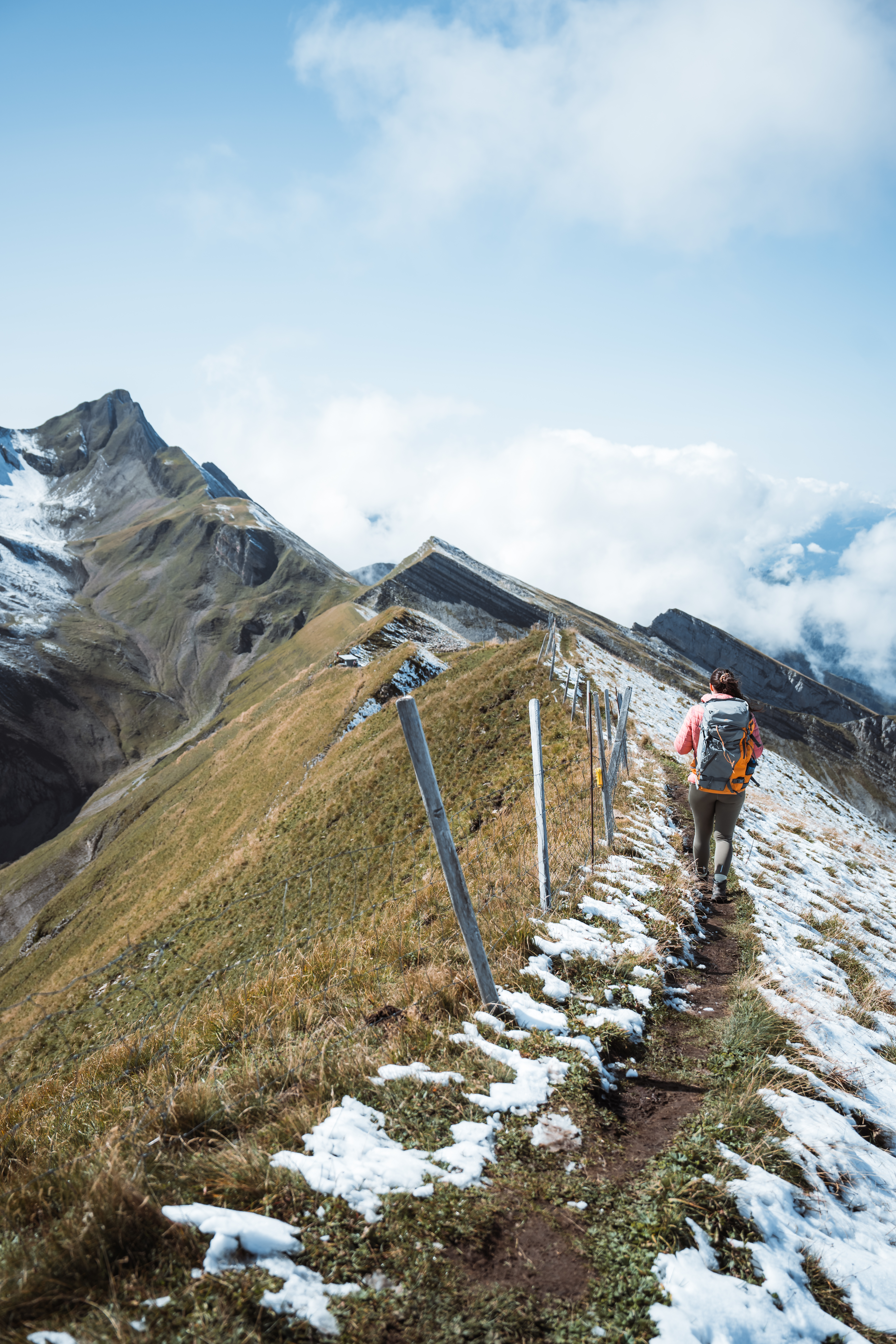 Eine Frau bei der Gratwanderung am Risetenstock mit Schnee.