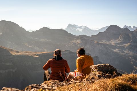 Zwei Personen am Picknicken mit Aussicht auf die Berge.