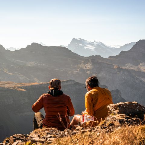 Zwei Personen am Picknicken mit Aussicht auf die Berge.
