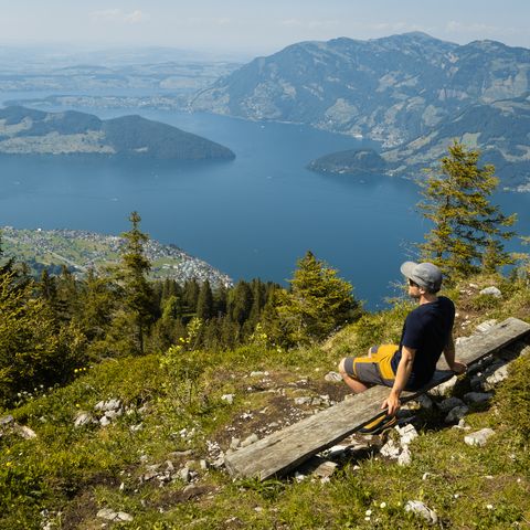 Eine Person geniesst die Aussicht auf den Vierwaldstättersee am Stollen auf der Klewenalp.