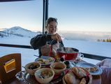 Eine Frau geniesst ein Fondue in der PanoramaBar auf der Klewenalp.
