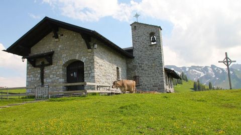 Klewenkappelle auf der Klewenalp im Sommer mit einer Kuh.