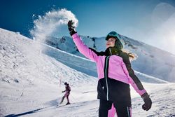 Ein Kind wirft Schnee auf auf der Klewenalp-Stockhütte