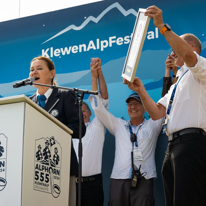 Das Organisationskommitee präsentiert stolz die Urkunde von Guinness World Record zum geschafften Alphorn-Weltrekord.