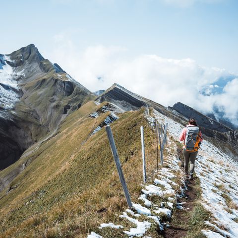 Eine Frau bei der Gratwanderung am Risetenstock mit Schnee.