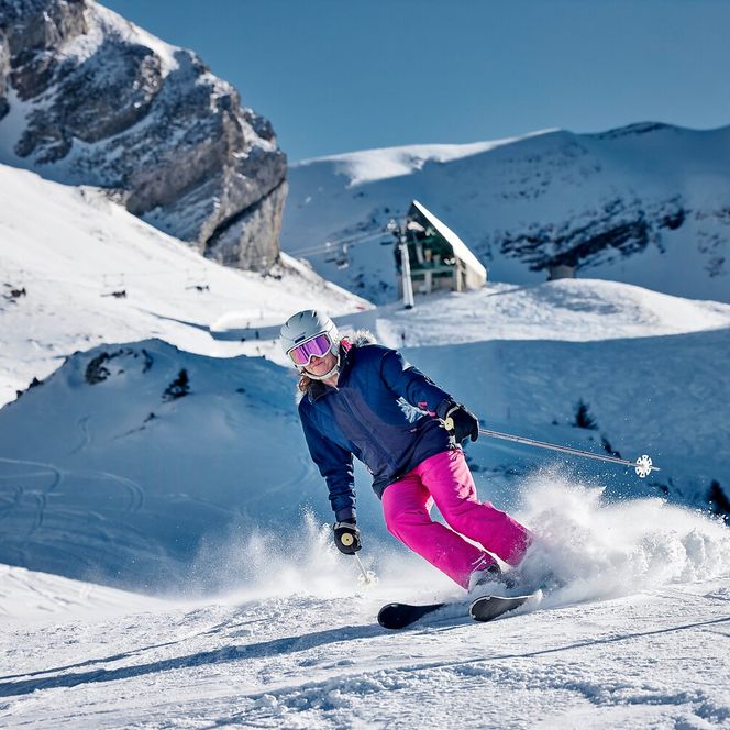 Eine Skifahrerin auf der Klewenalp mit der Sesselbahn Chälen im Hintergrund.