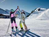 Zwei Frauen geben sich Highfive beim Skifahren auf der Klewenalp